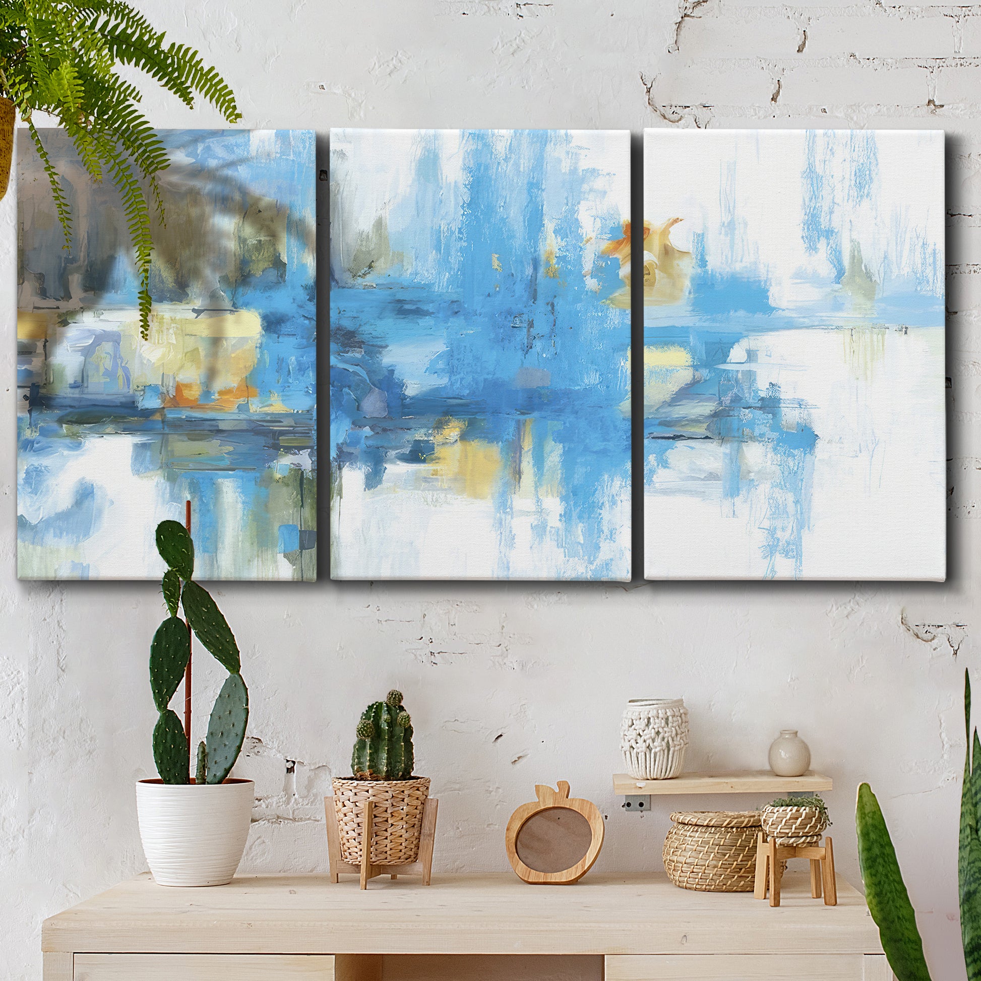 Three-panel canvas wall art featuring blue toned abstract city rhythm, displayed in a boho-chic entryway above a console table.
