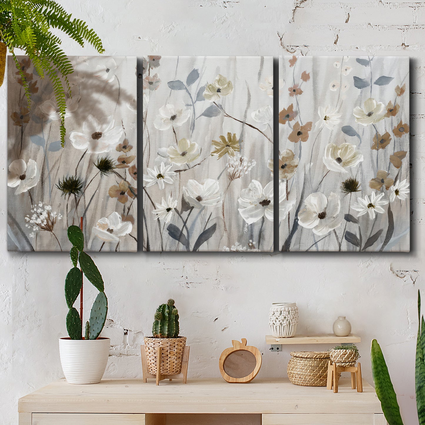 Three-panel canvas wall art featuring misty wildflower meadow landscape, displayed in a boho-chic entryway above a console table.