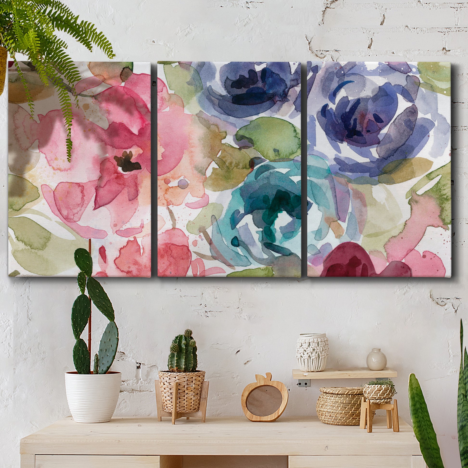 Three-panel canvas wall art featuring soft floral watercolor composition, displayed in a boho-chic entryway above a console table.