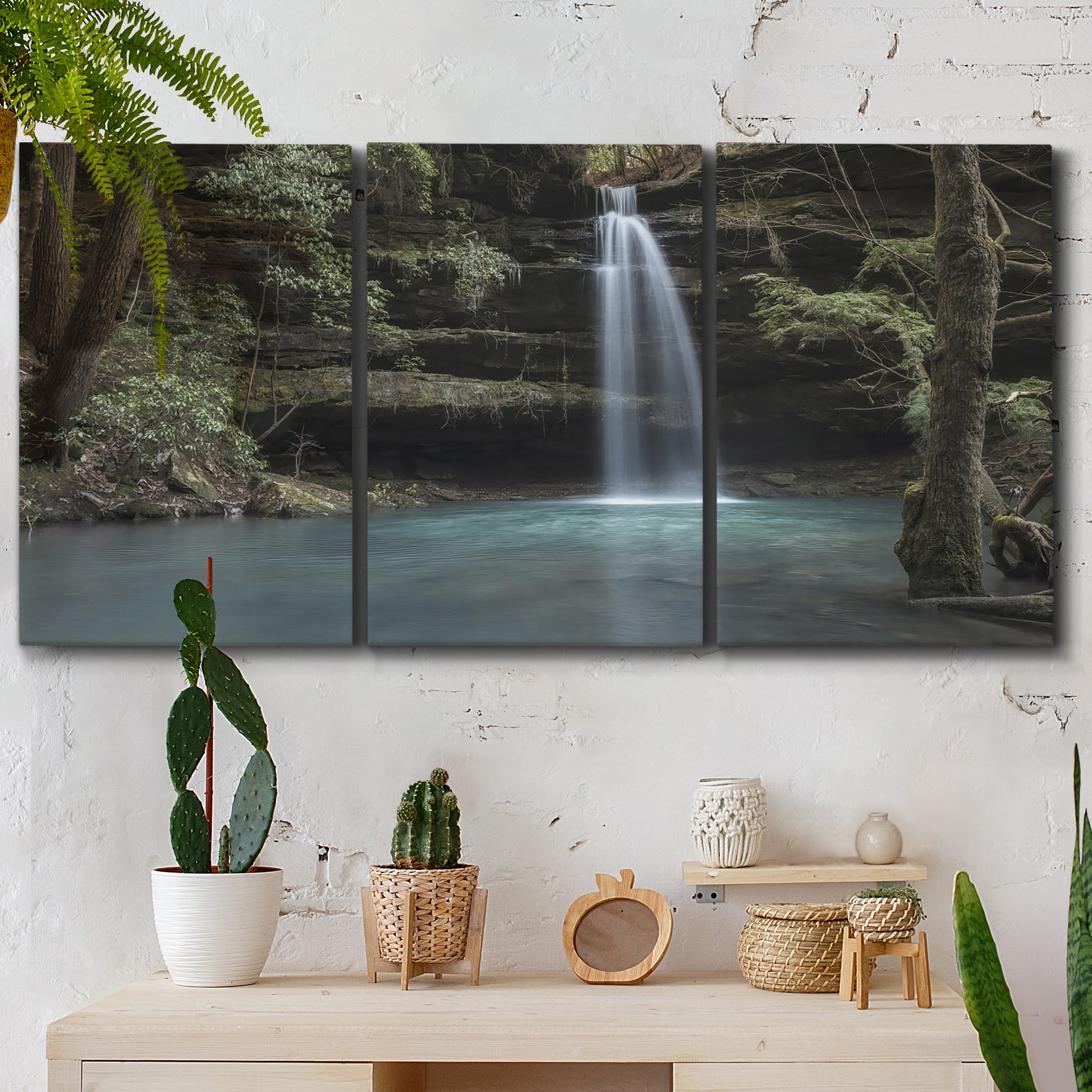 Three-panel canvas wall art featuring waterfall cascading through forest, displayed in a boho-chic entryway above a console table.