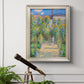 Impressionist garden landscape painting by Claude Monet in an ornate champagne frame displayed in a light-toned interior setting.