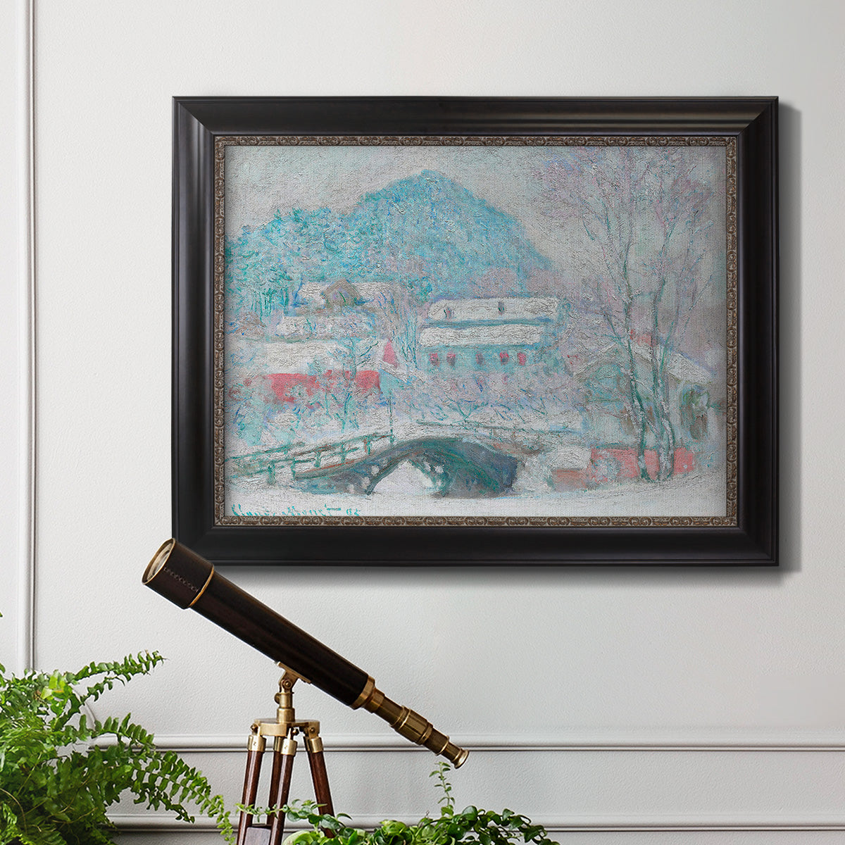 Impressionist coastal village landscape in Norway by Claude Monet in an ornate black frame with gilded inner detail displayed in a light-toned interior setting.