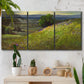 Three-panel canvas wall art featuring winding path through rolling hills, displayed in a boho-chic entryway above a console table.