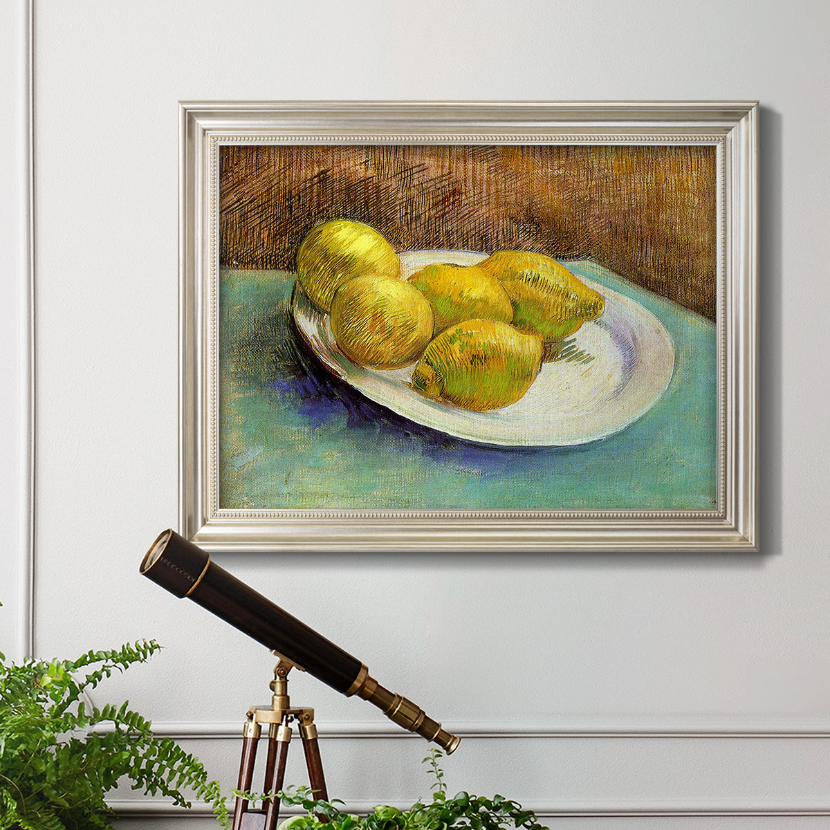 Impressionist still life with lemons by Vincent van Gogh in an ornate champagne frame displayed in a light-toned interior setting.