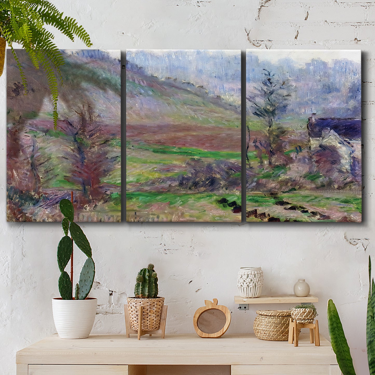 Three-panel canvas wall art featuring cliffside cottage overlooking sea, displayed in a boho-chic entryway above a console table.