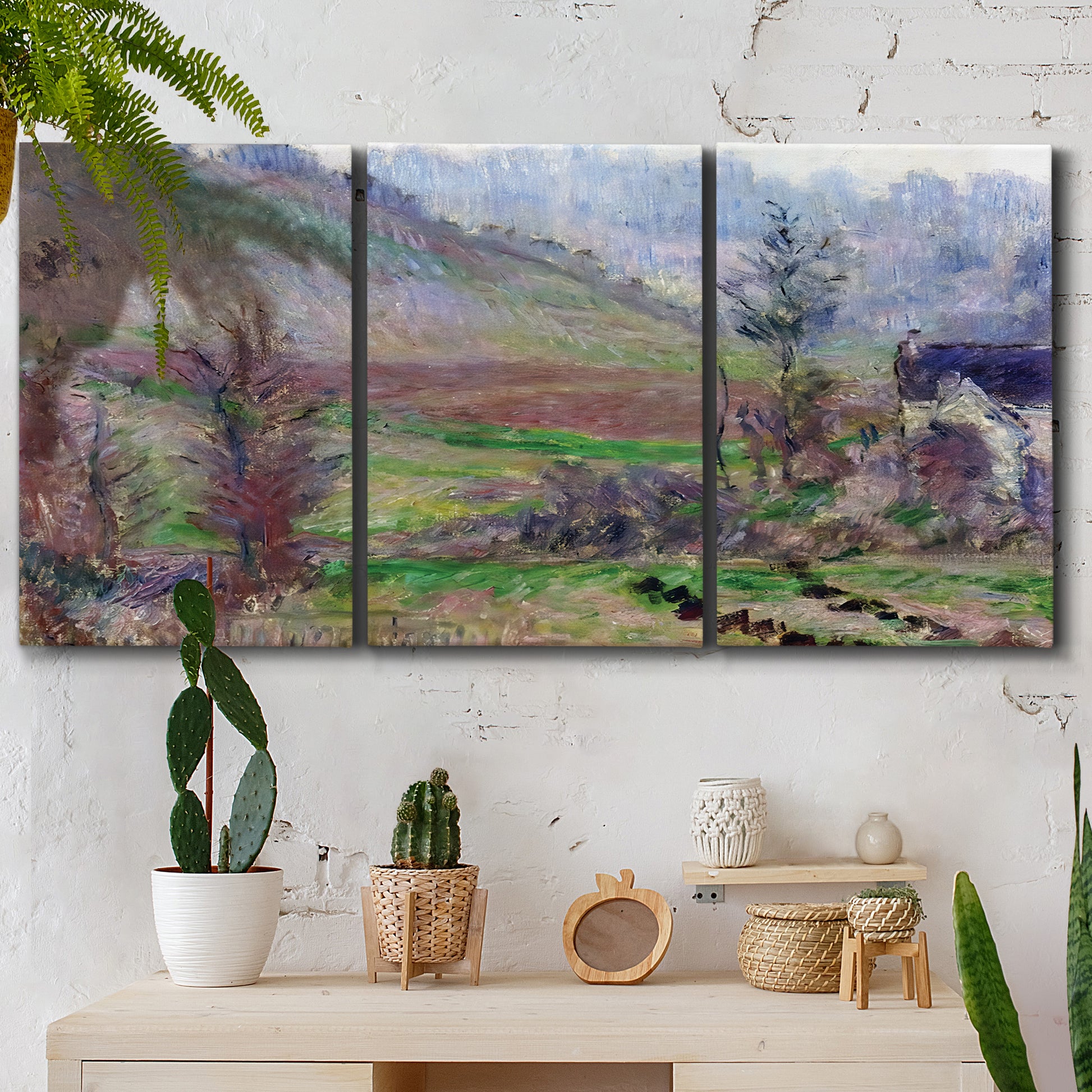 Three-panel canvas wall art featuring cliffside cottage overlooking sea, displayed in a boho-chic entryway above a console table.