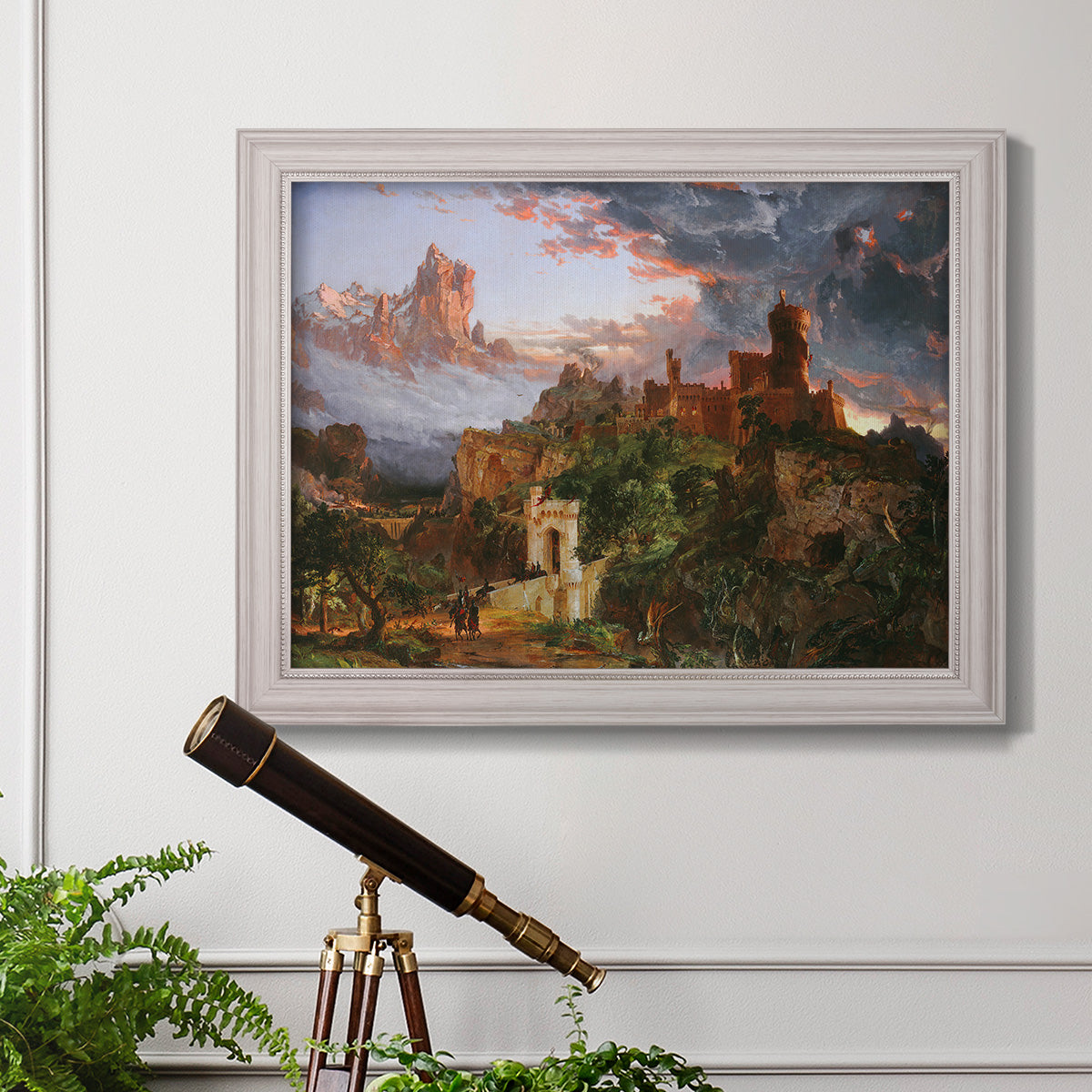 Romantic allegorical landscape painting by Jasper Francis Cropsey in an ornate weathered white frame displayed in a light-toned interior setting.
