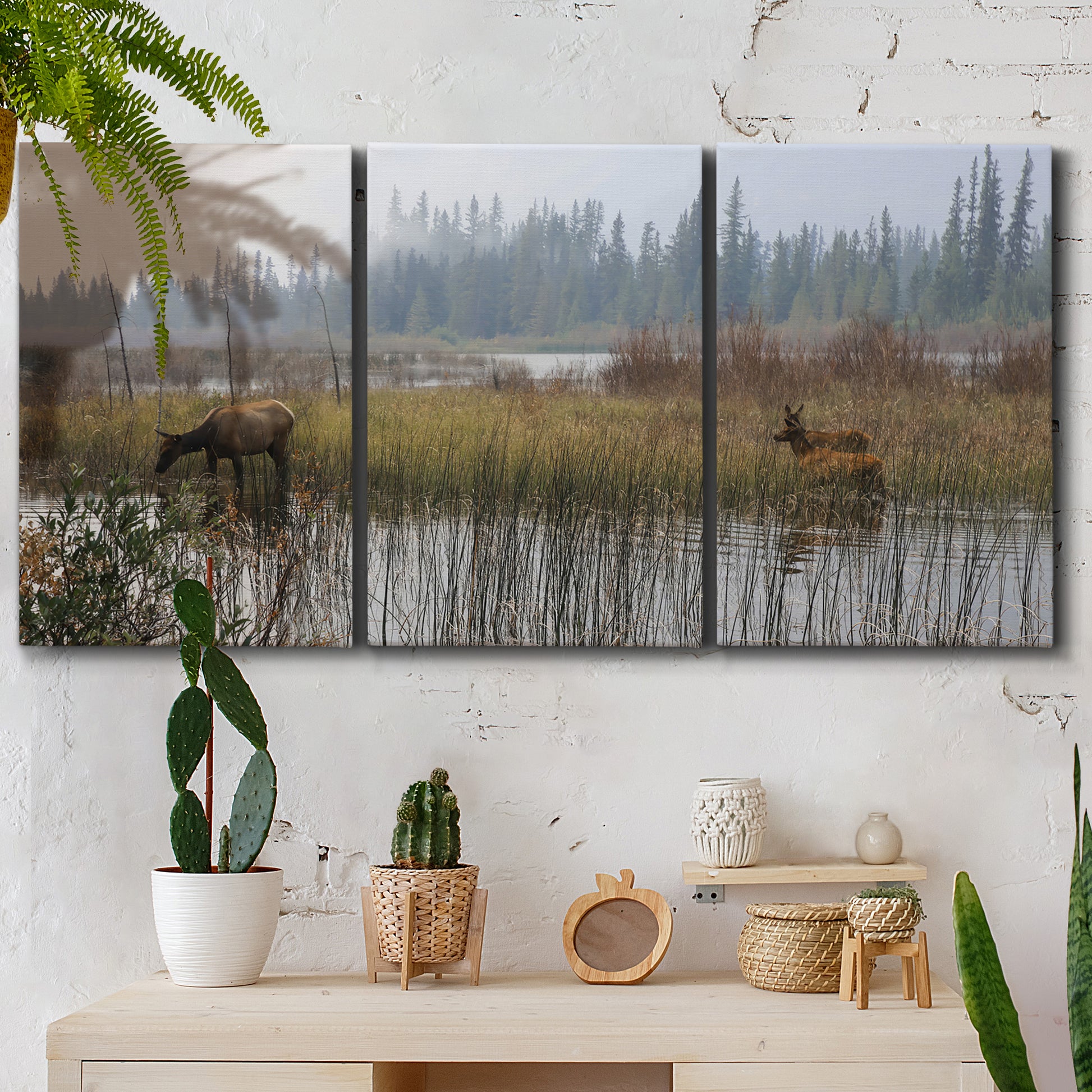 Three-panel canvas wall art featuring wildlife walking through open field, displayed in a boho-chic entryway above a console table.