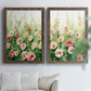 Set of two walnut barnwood framed canvas prints depicting loose blossoms, green stems, and sunlit watercolor texture arranged across two complementary compositions above a sofa in a bright living space.