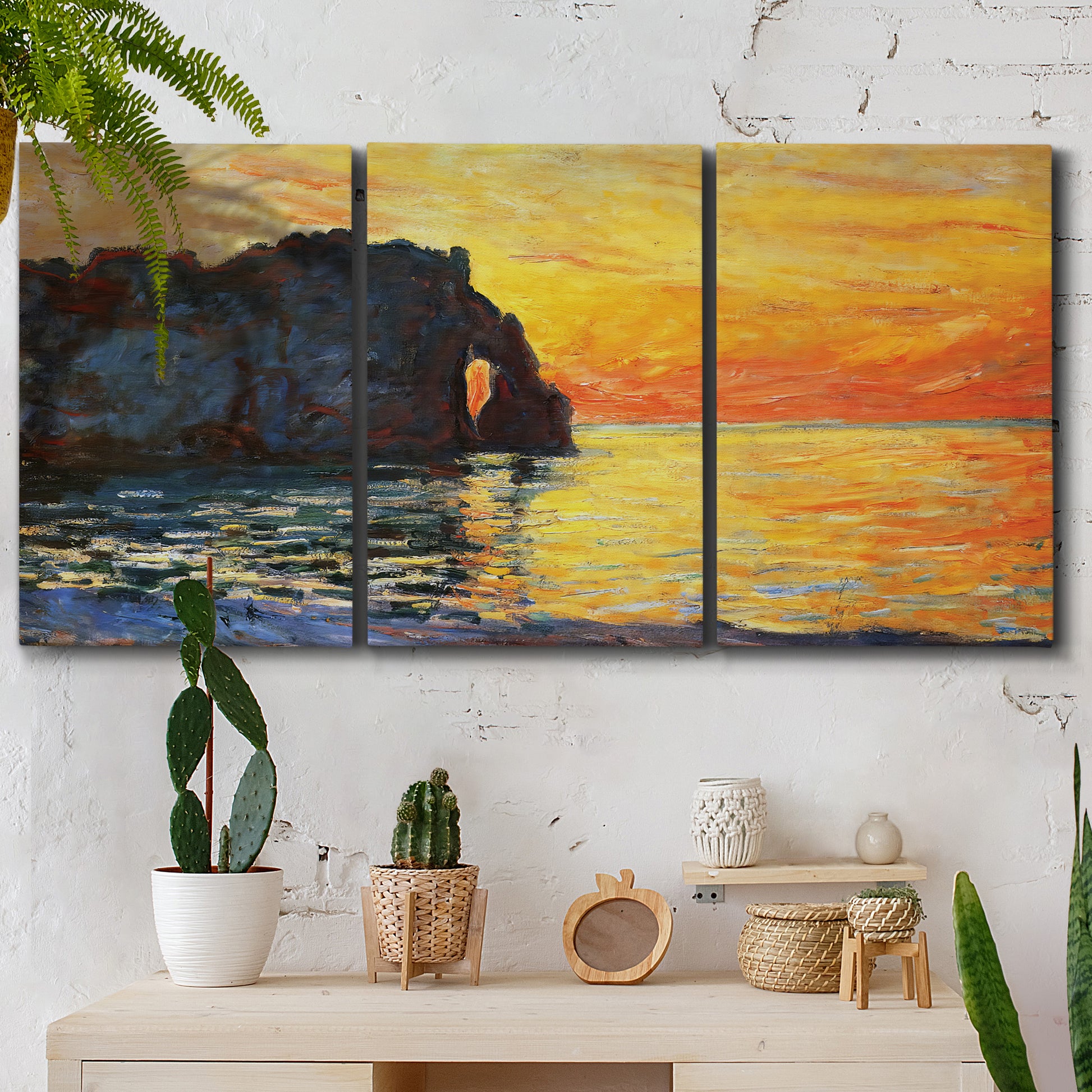 Three-panel canvas wall art featuring arched coastal cliff above sea, displayed in a boho-chic entryway above a console table.