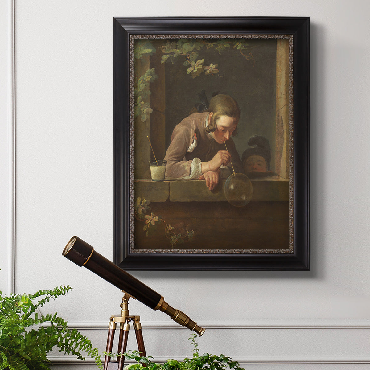 Classical genre painting of a child blowing soap bubbles by Jean-Siméon Chardin in an ornate black frame with gilded inner detail displayed in a light-toned interior setting.
