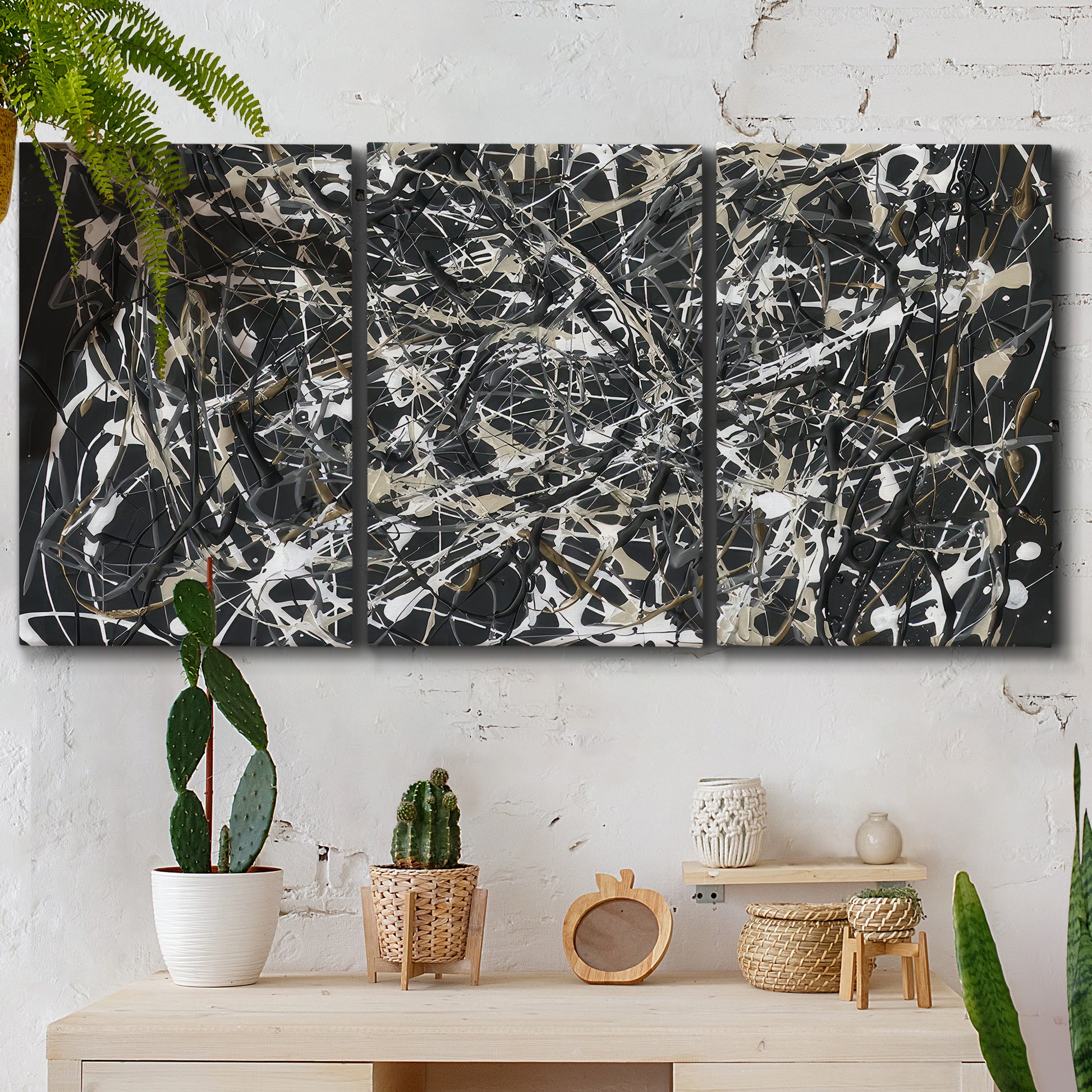 Three-panel canvas wall art featuring energetic expressionist abstract splatter, displayed in a boho-chic entryway above a console table.