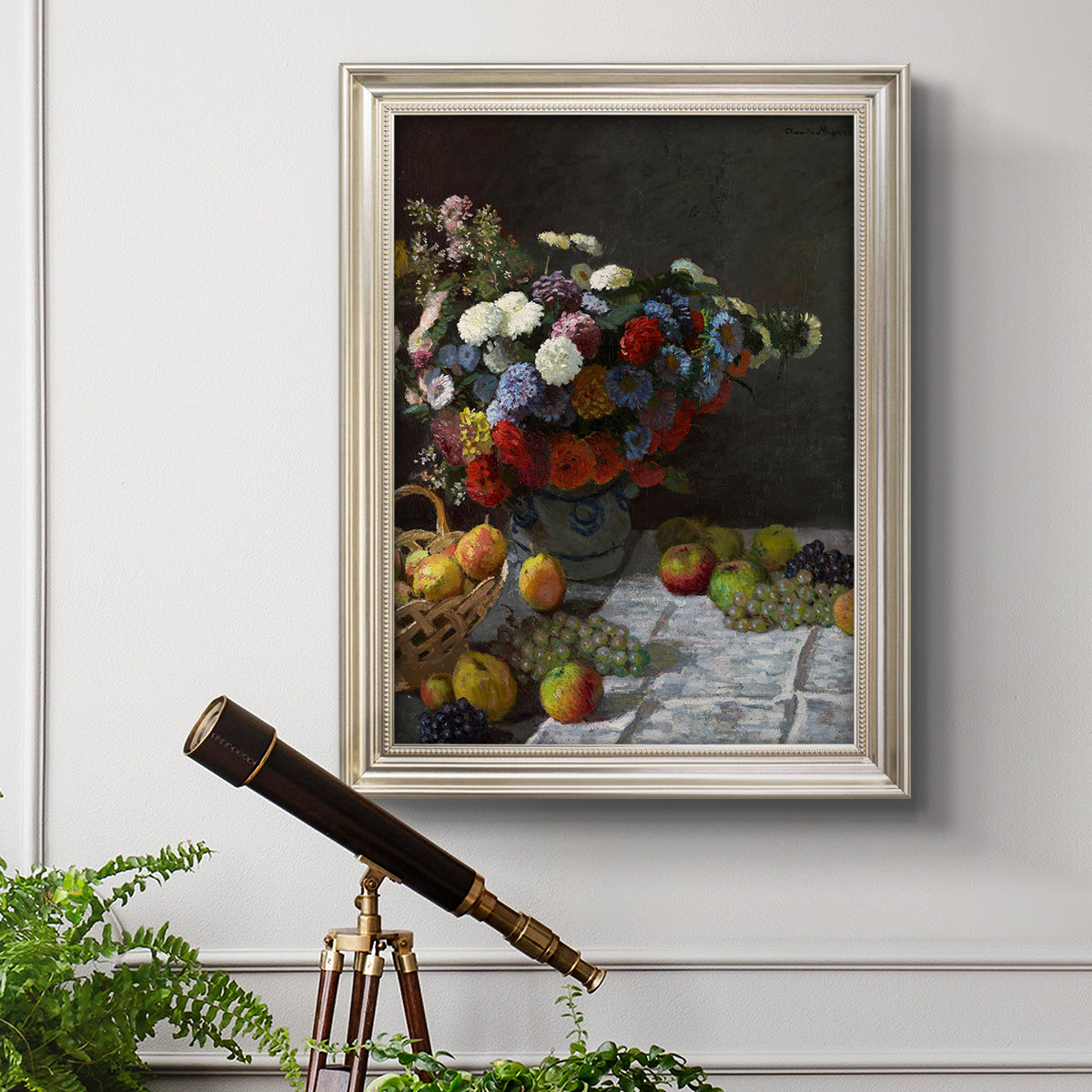 Impressionist floral still life painting by Claude Monet in an ornate champagne frame displayed in a light-toned interior setting.
