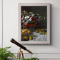 Impressionist floral still life painting by Claude Monet in an ornate weathered white frame displayed in a light-toned interior setting.