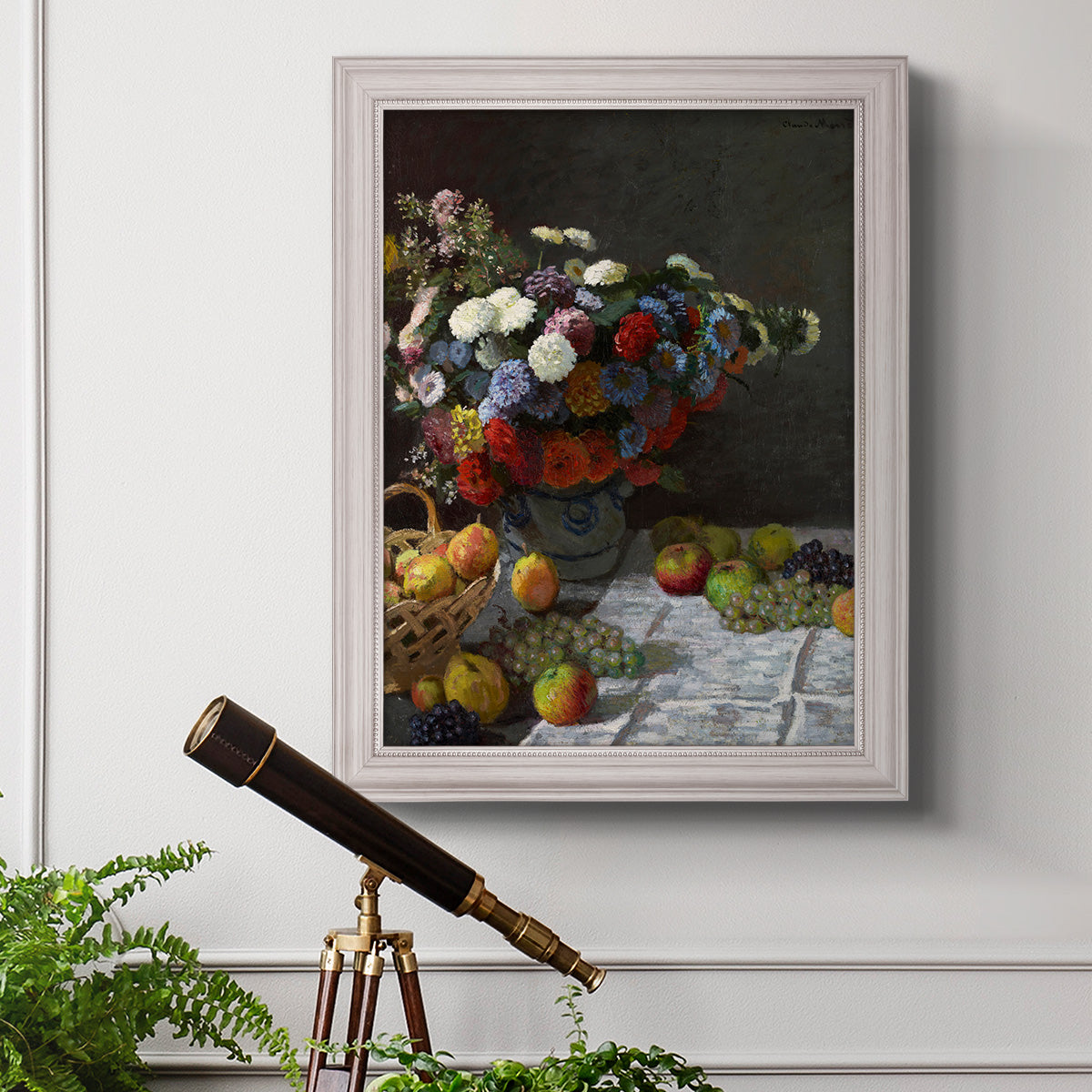 Impressionist floral still life painting by Claude Monet in an ornate weathered white frame displayed in a light-toned interior setting.