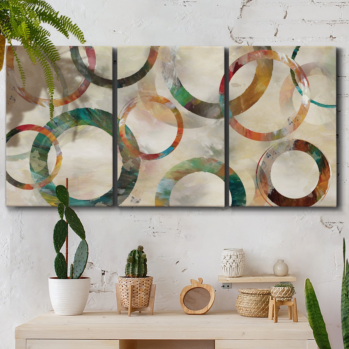 Three-panel canvas wall art featuring geometric circular abstract design, displayed in a boho-chic entryway above a console table.