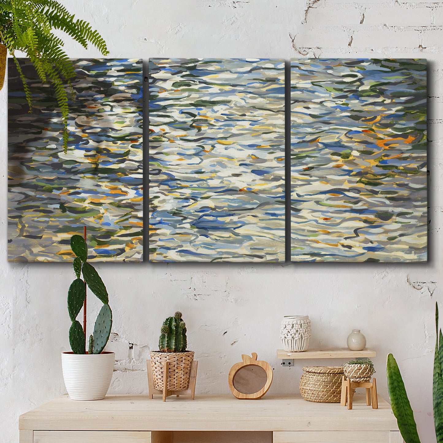 Three-panel canvas wall art featuring abstract water surface reflections, displayed in a boho-chic entryway above a console table.