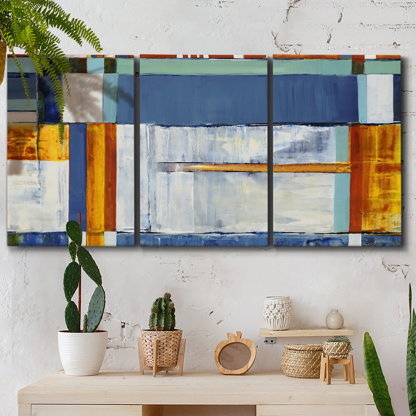 Three-panel canvas wall art featuring bright mid century geometric abstraction, displayed in a boho-chic entryway above a console table.