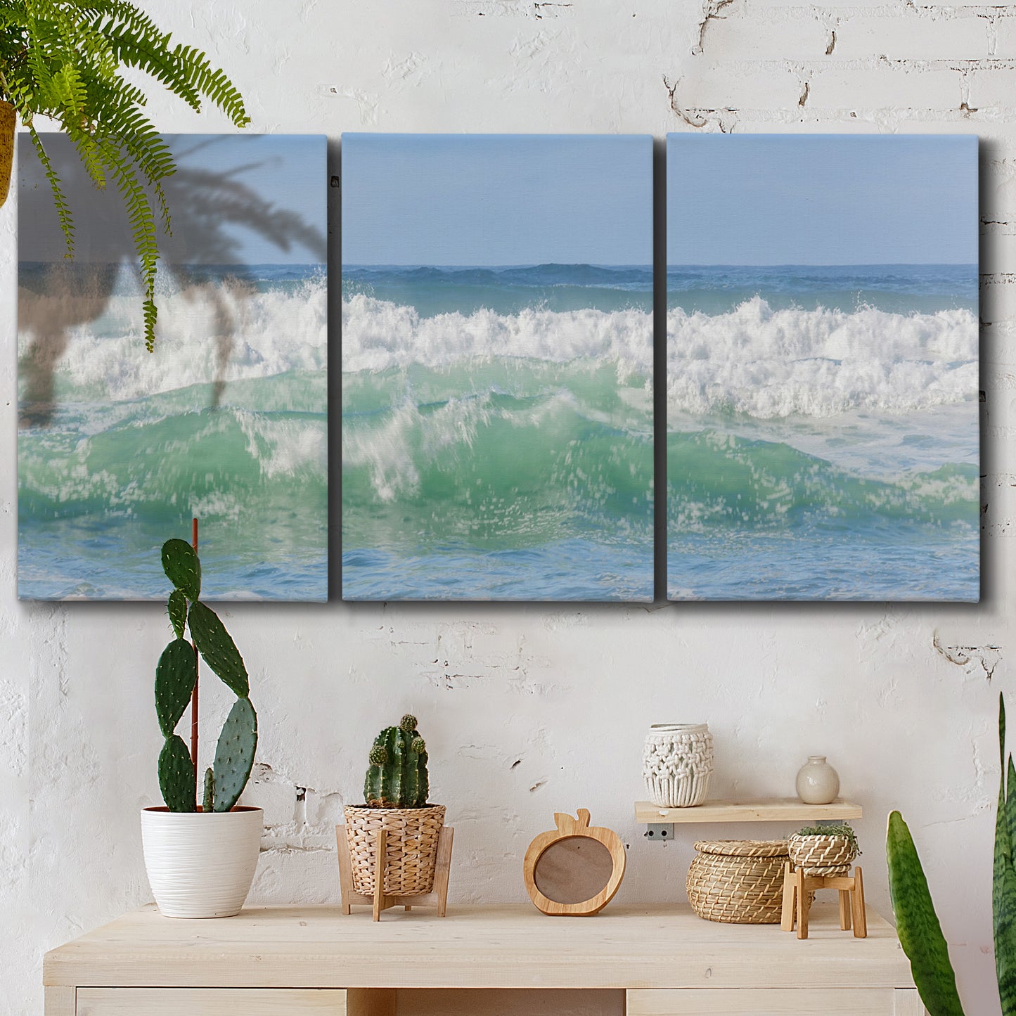 Three-panel canvas wall art featuring coastal waves breaking ashore, displayed in a boho-chic entryway above a console table.
