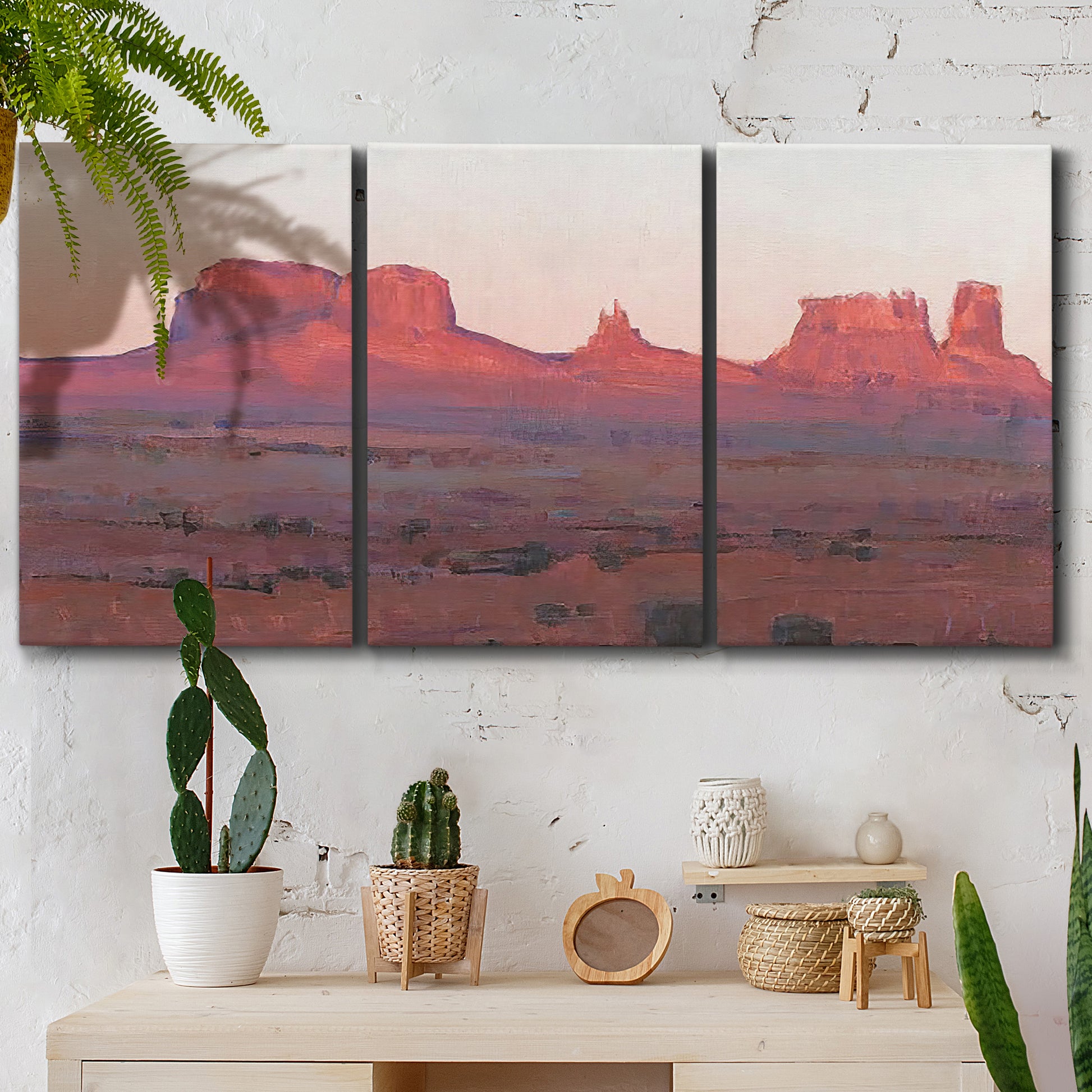 Three-panel canvas wall art featuring red rock desert formations at dusk, displayed in a boho-chic entryway above a console table.