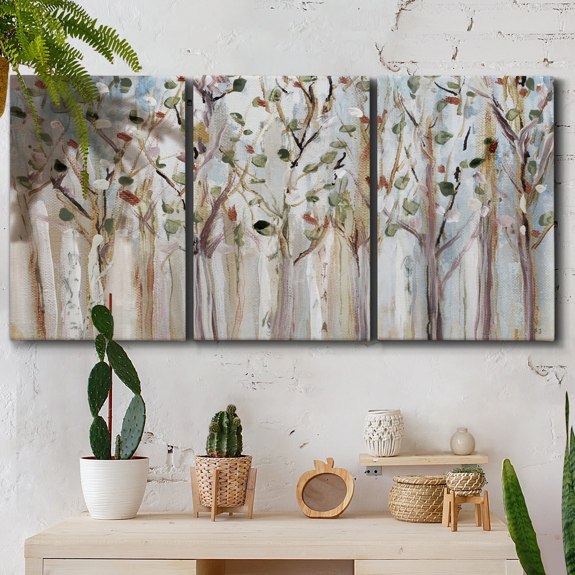 Three-panel canvas wall art featuring bare birch trees in winter forest, displayed in a boho-chic entryway above a console table.