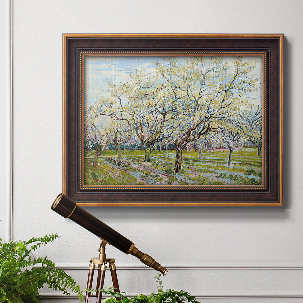 Impressionist white-blossomed orchard landscape by Vincent van Gogh in an ornate bronzed mahogany wood frame displayed in a light-toned interior setting.