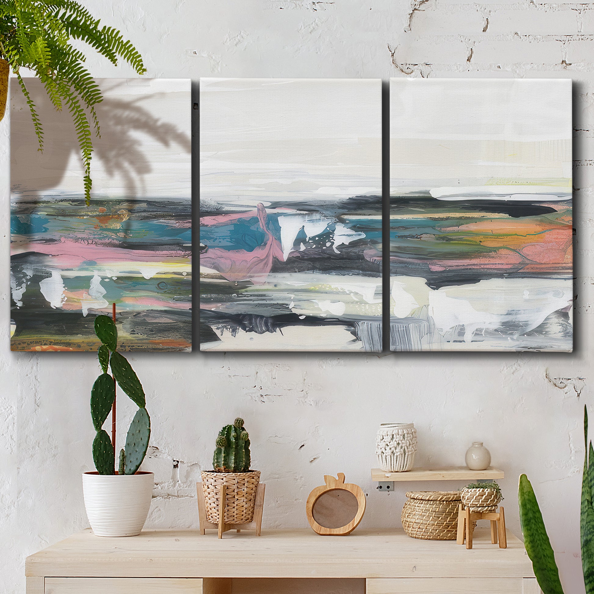 Three-panel canvas wall art featuring cheerful abstract coastal seascape, displayed in a boho-chic entryway above a console table.