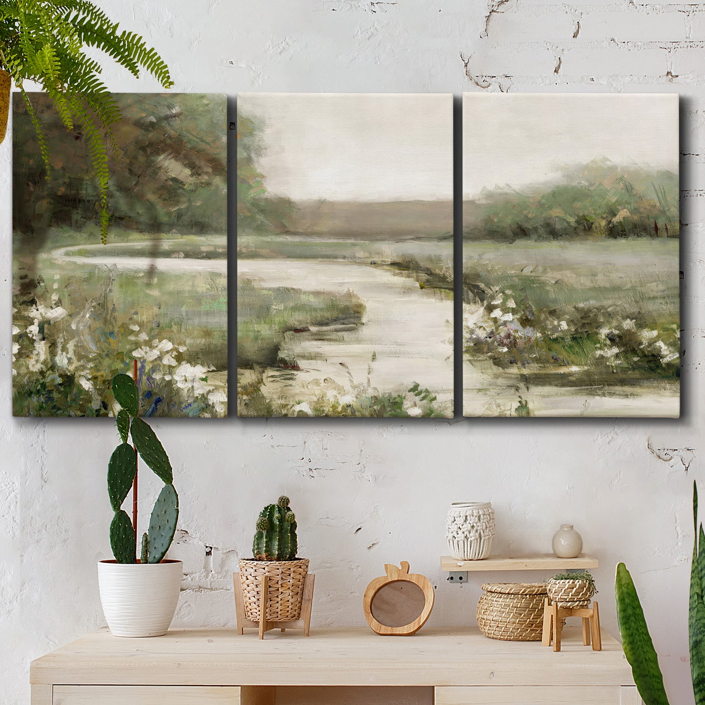 Three-panel canvas wall art featuring narrow path through quiet landscape, displayed in a boho-chic entryway above a console table.