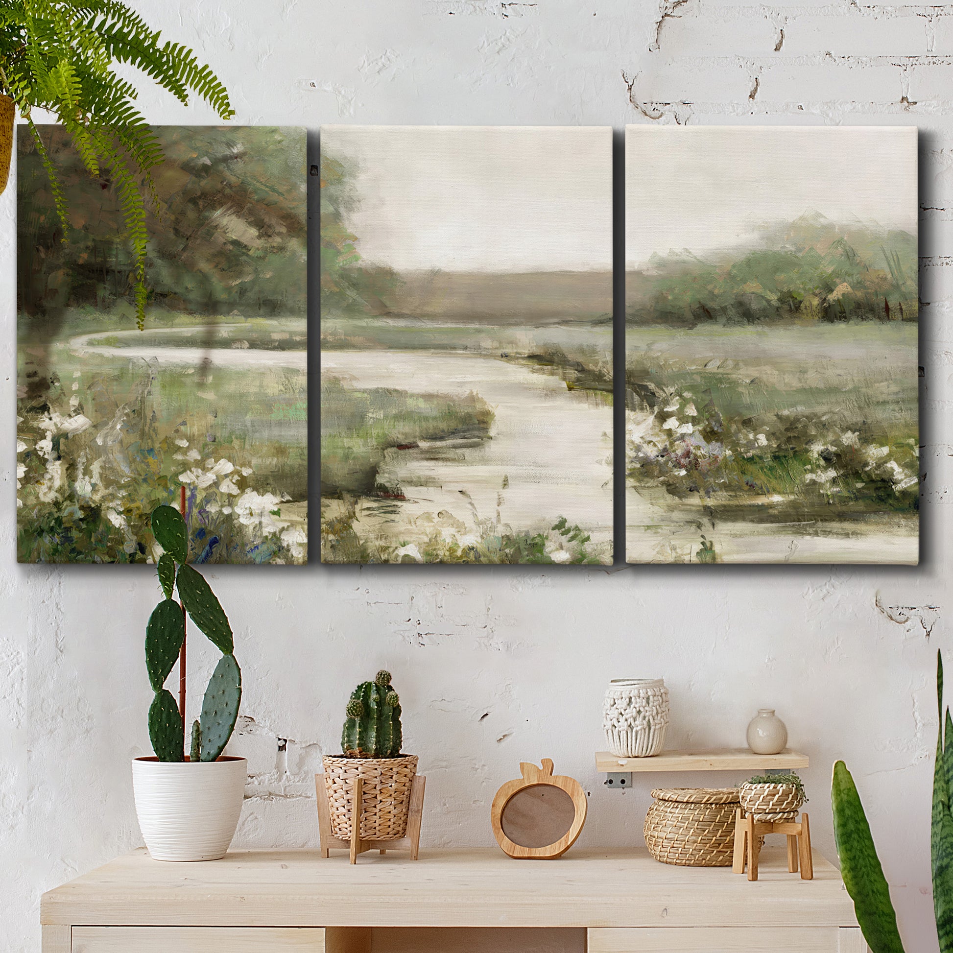 Three-panel canvas wall art featuring narrow path through quiet landscape, displayed in a boho-chic entryway above a console table.