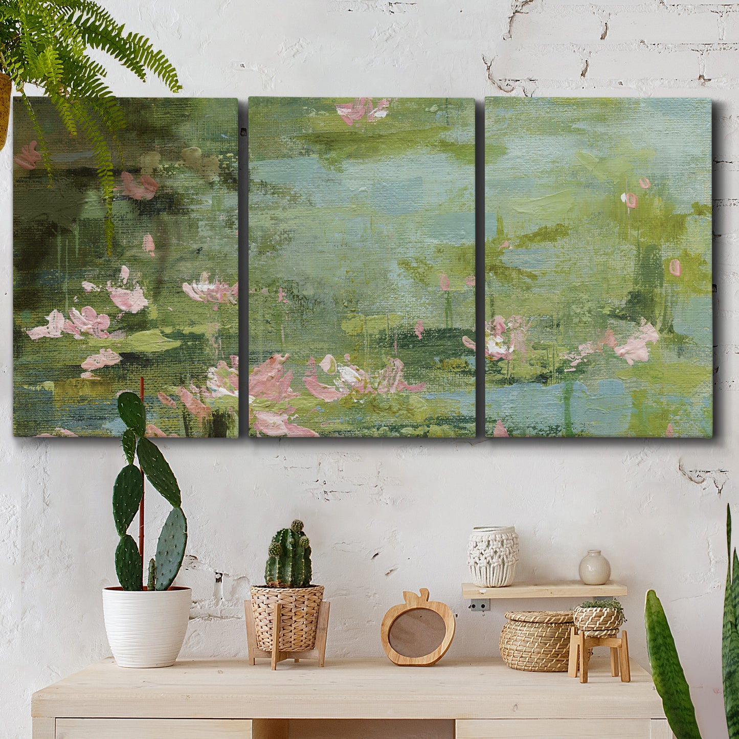 Three-panel canvas wall art featuring muted water lily pond, displayed in a boho-chic entryway above a console table.