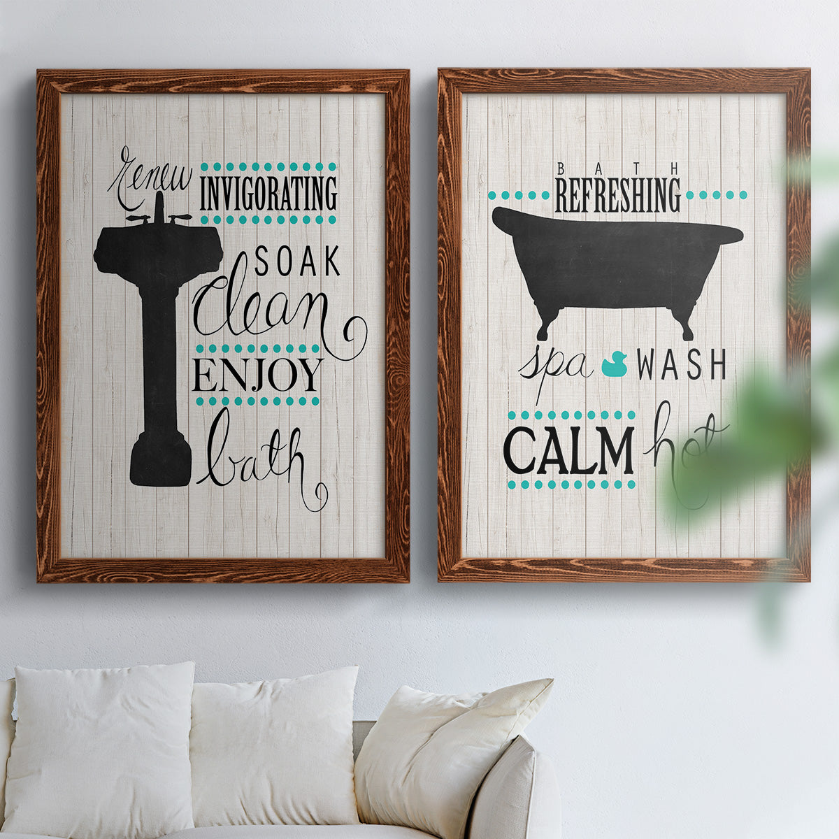 Set of two maple barnwood framed canvas prints depicting black tubs, hand-lettered phrases, and small teal accents arranged across two complementary compositions above a sofa in a bright living space.