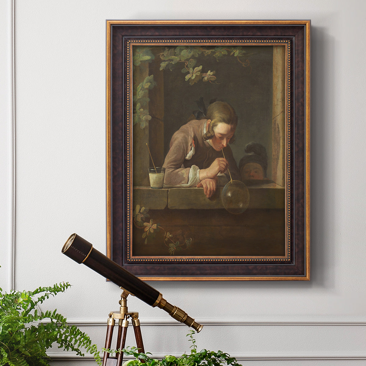 Classical genre painting of a child blowing soap bubbles by Jean-Siméon Chardin in an ornate bronzed mahogany wood frame displayed in a light-toned interior setting.