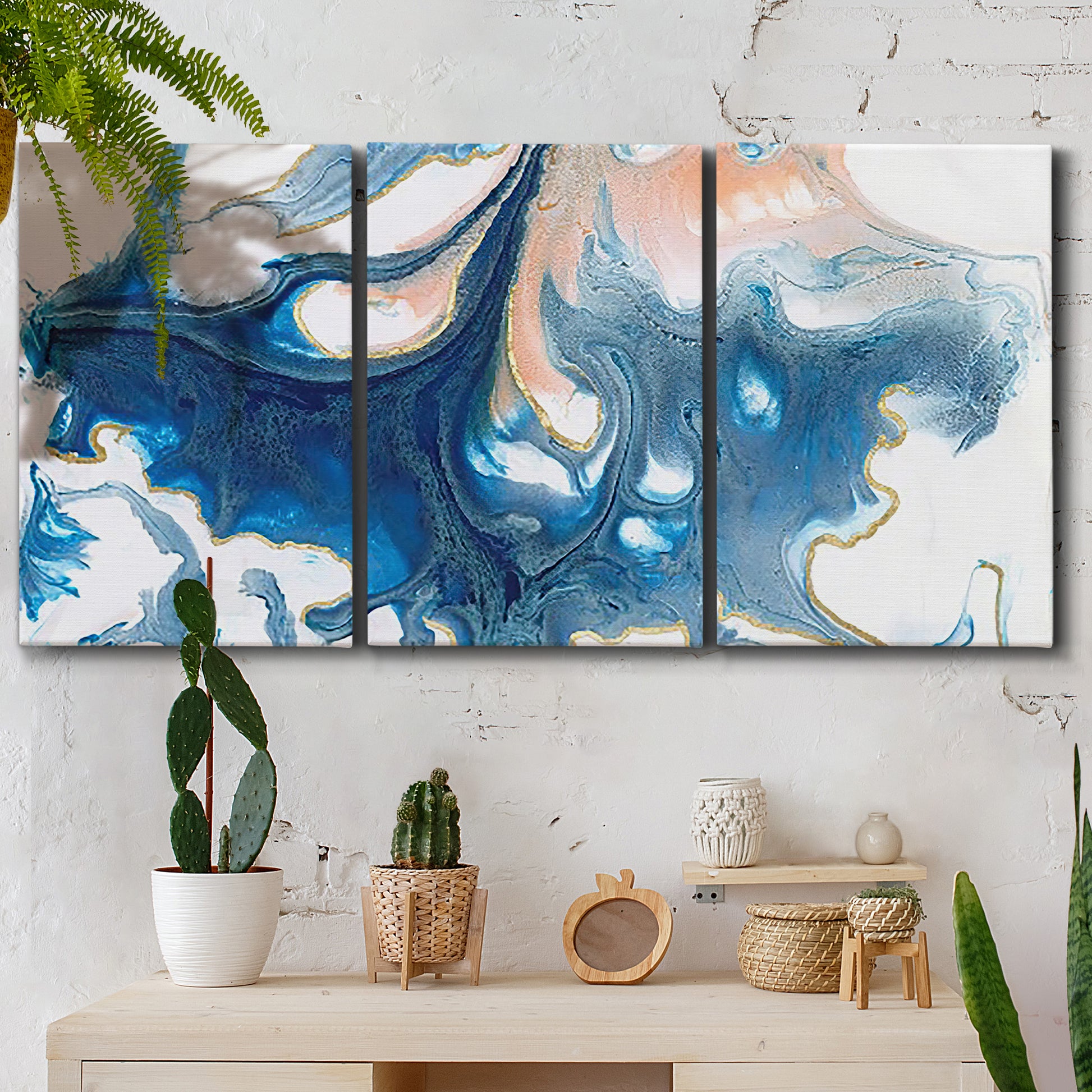 Three-panel canvas wall art featuring flowing blue abstract movement, displayed in a boho-chic entryway above a console table.