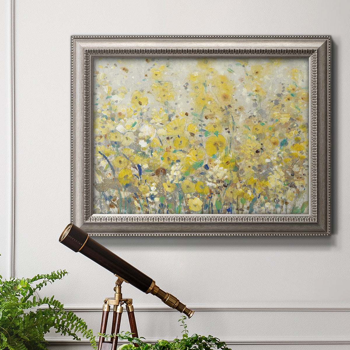 Impressionist floral garden painting in an ornate vintage silver frame displayed in a light-toned interior setting.