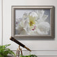 Soft white peony close-up in an ornate vintage silver frame displayed in a light-toned interior setting.