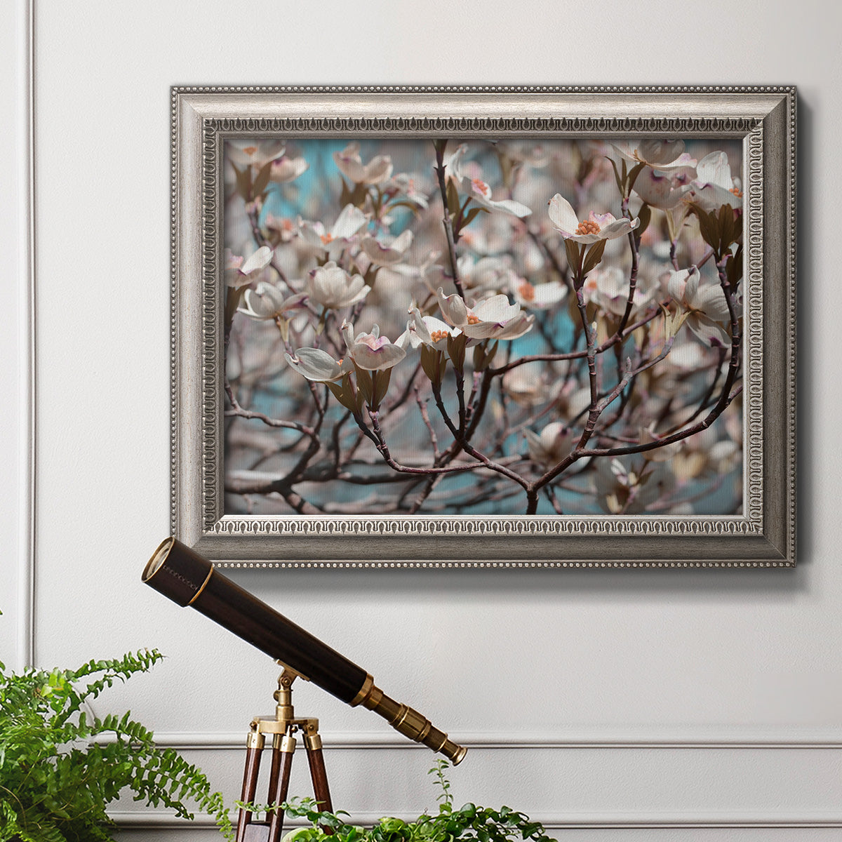 Contemporary dogwood blossom floral photography in an ornate vintage silver frame displayed in a light-toned interior setting.