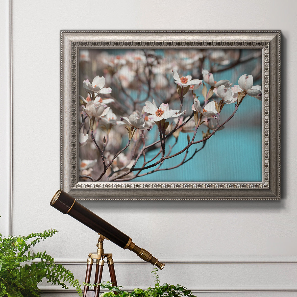 Color-rich dogwood floral photography in an ornate vintage silver frame displayed in a light-toned interior setting.