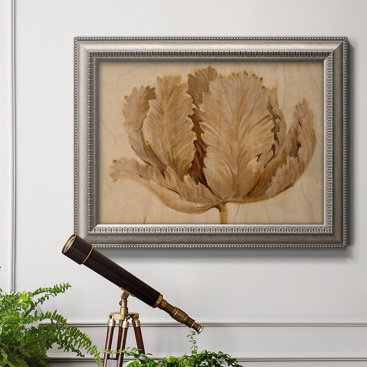 Monochrome sepia tulip flower in an ornate vintage silver frame displayed in a light-toned interior setting.
