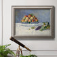 Impressionist still life painting with peaches and grapes in an ornate vintage silver frame displayed in a light-toned interior setting.
