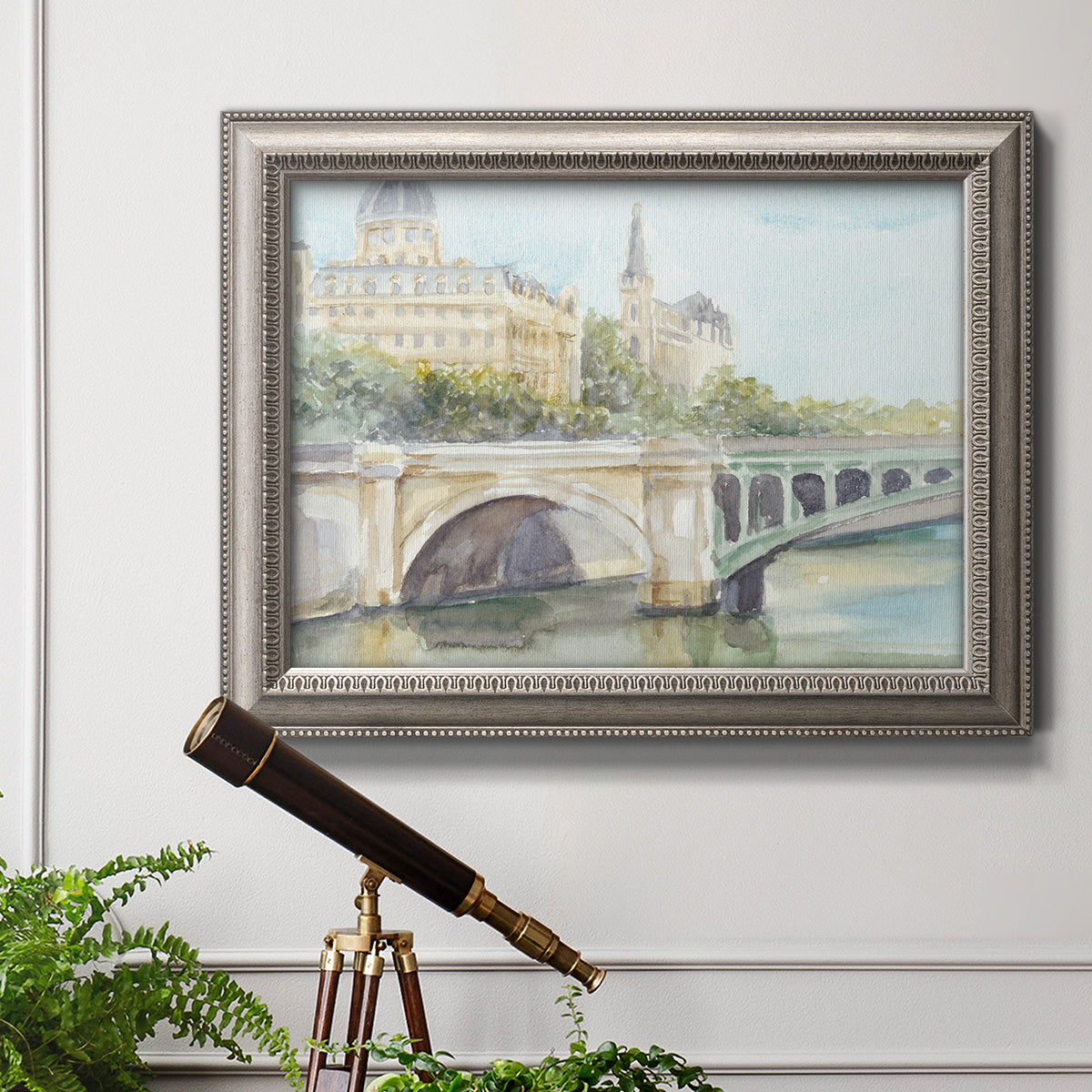 Classical watercolor painting of a French bridge in an ornate vintage silver frame displayed in a light-toned interior setting.