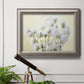 Soft-focus baby’s breath flower photograph in an ornate vintage silver frame displayed in a light-toned interior setting.