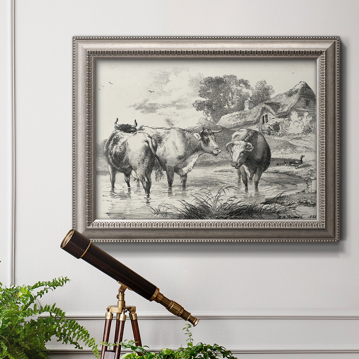 Classical rural landscape artwork by Nicolas Berchem in an ornate vintage silver frame displayed in a light-toned interior setting.