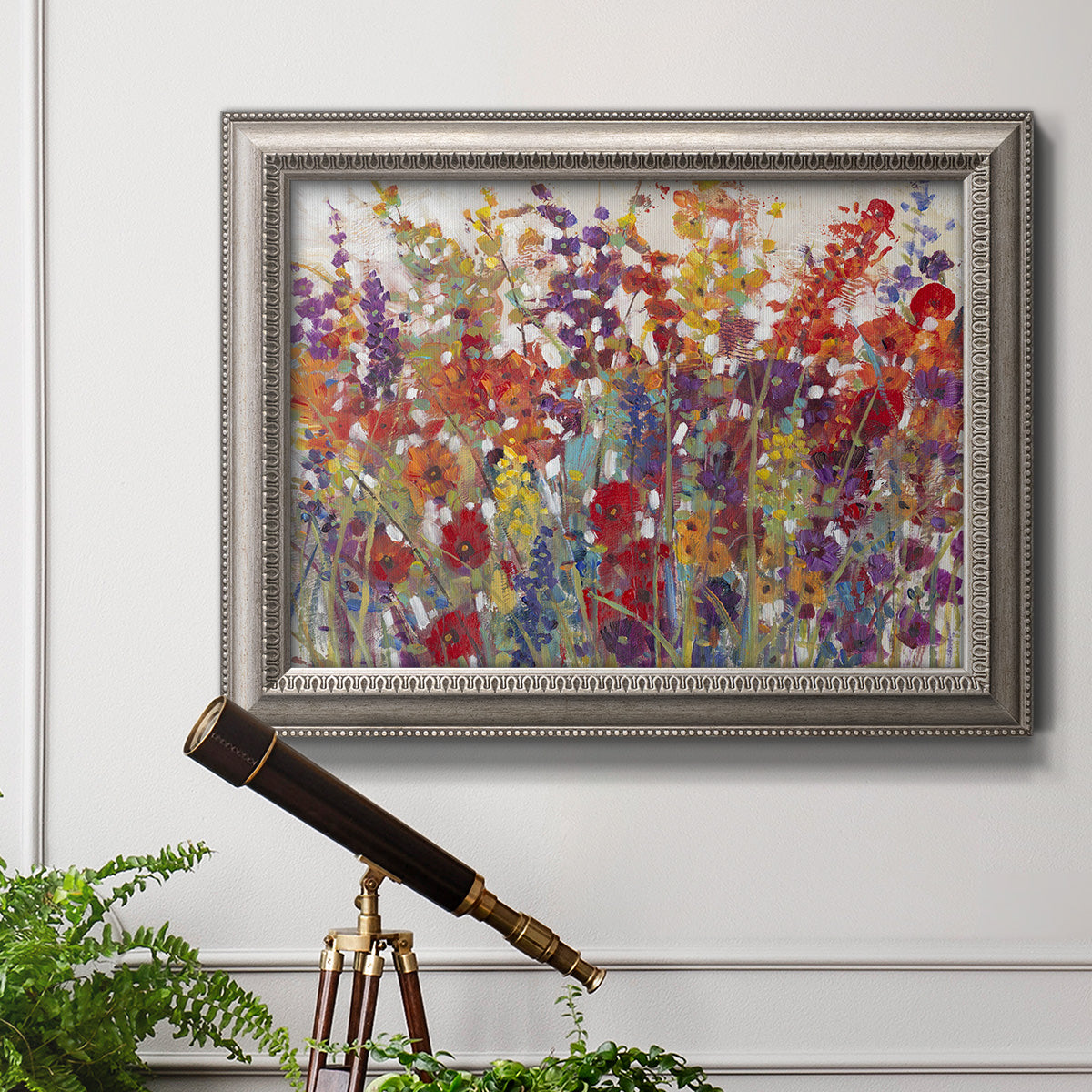 Impressionist floral bouquet artwork in an ornate vintage silver frame displayed in a light-toned interior setting.