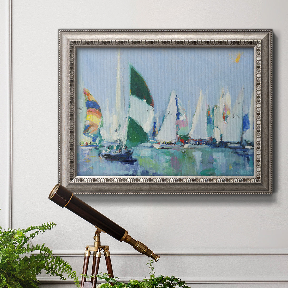 Coastal harbor watercolor painting in an ornate vintage silver frame displayed in a light-toned interior setting.