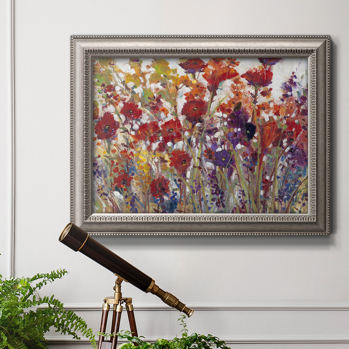 French country floral bouquet painting in an ornate vintage silver frame displayed in a light-toned interior setting.