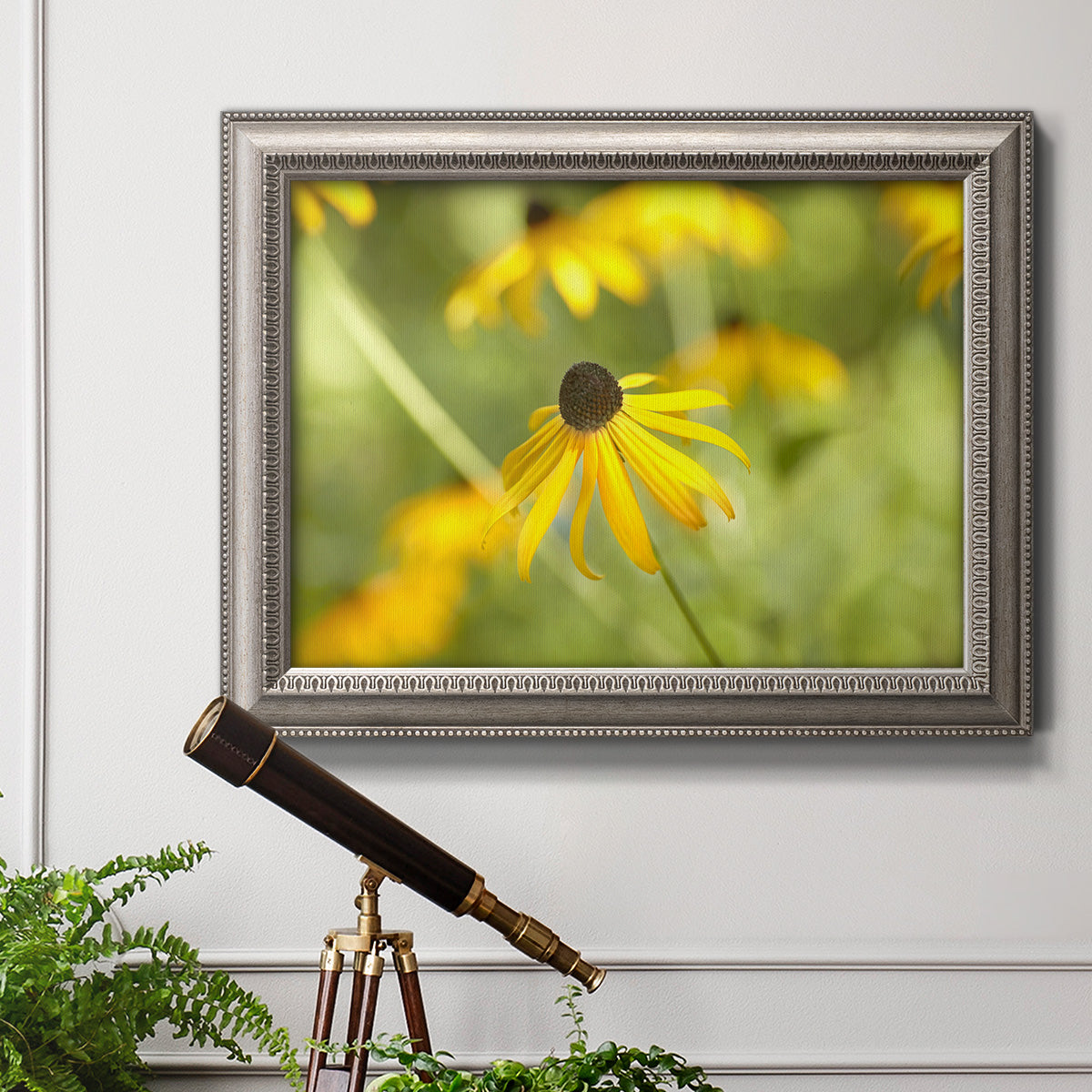 Contemporary black-eyed Susan flower photography in an ornate vintage silver frame displayed in a light-toned interior setting.