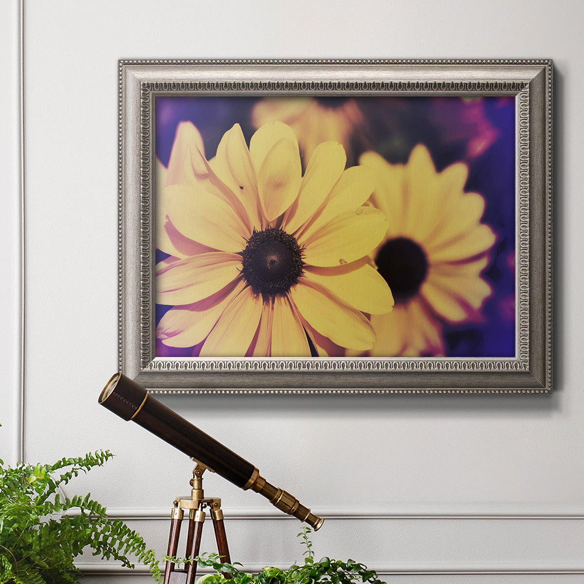 Bright black-eyed Susan flower photography in an ornate vintage silver frame displayed in a light-toned interior setting.