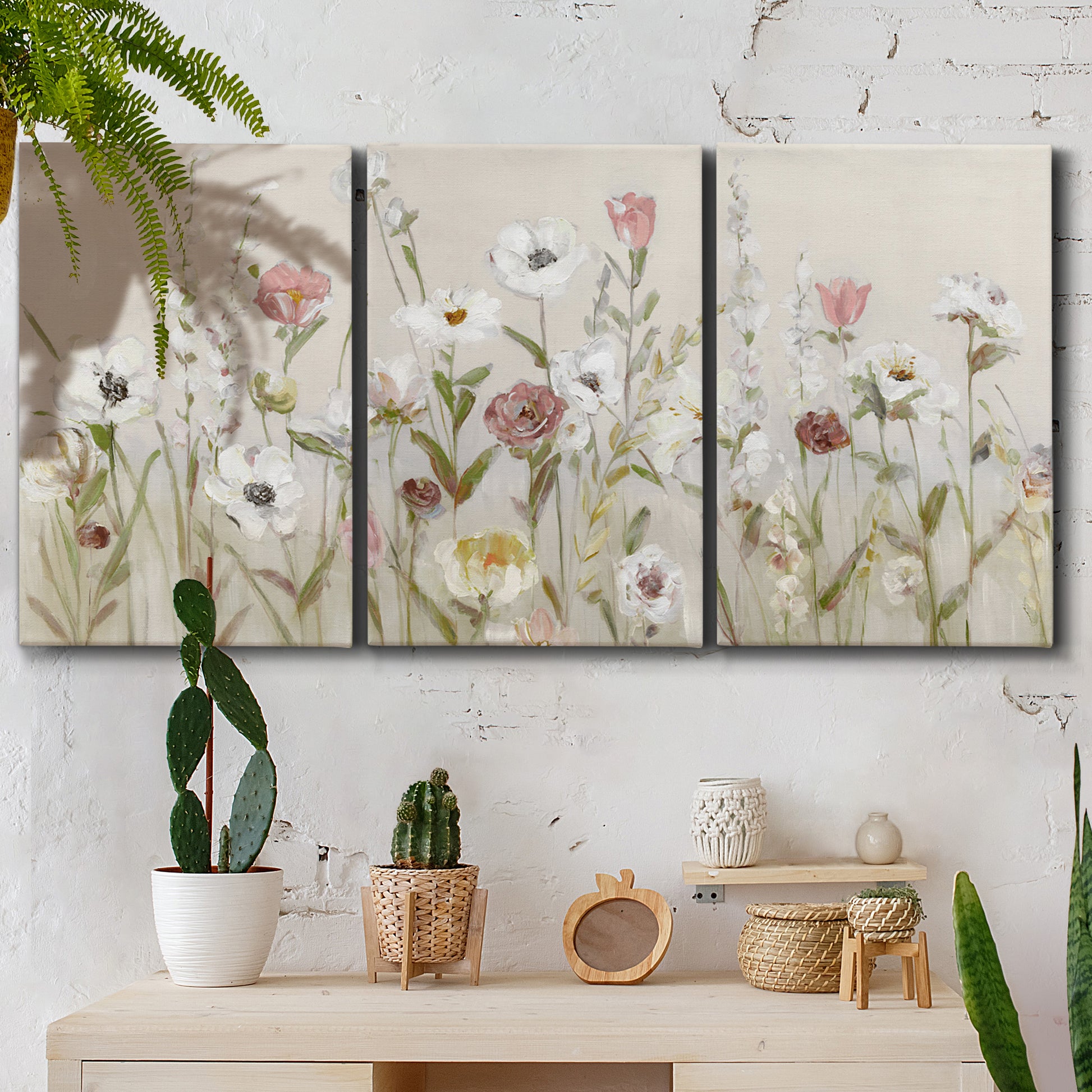 Three-panel canvas wall art featuring loose farmhouse style floral painting, displayed in a boho-chic entryway above a console table.