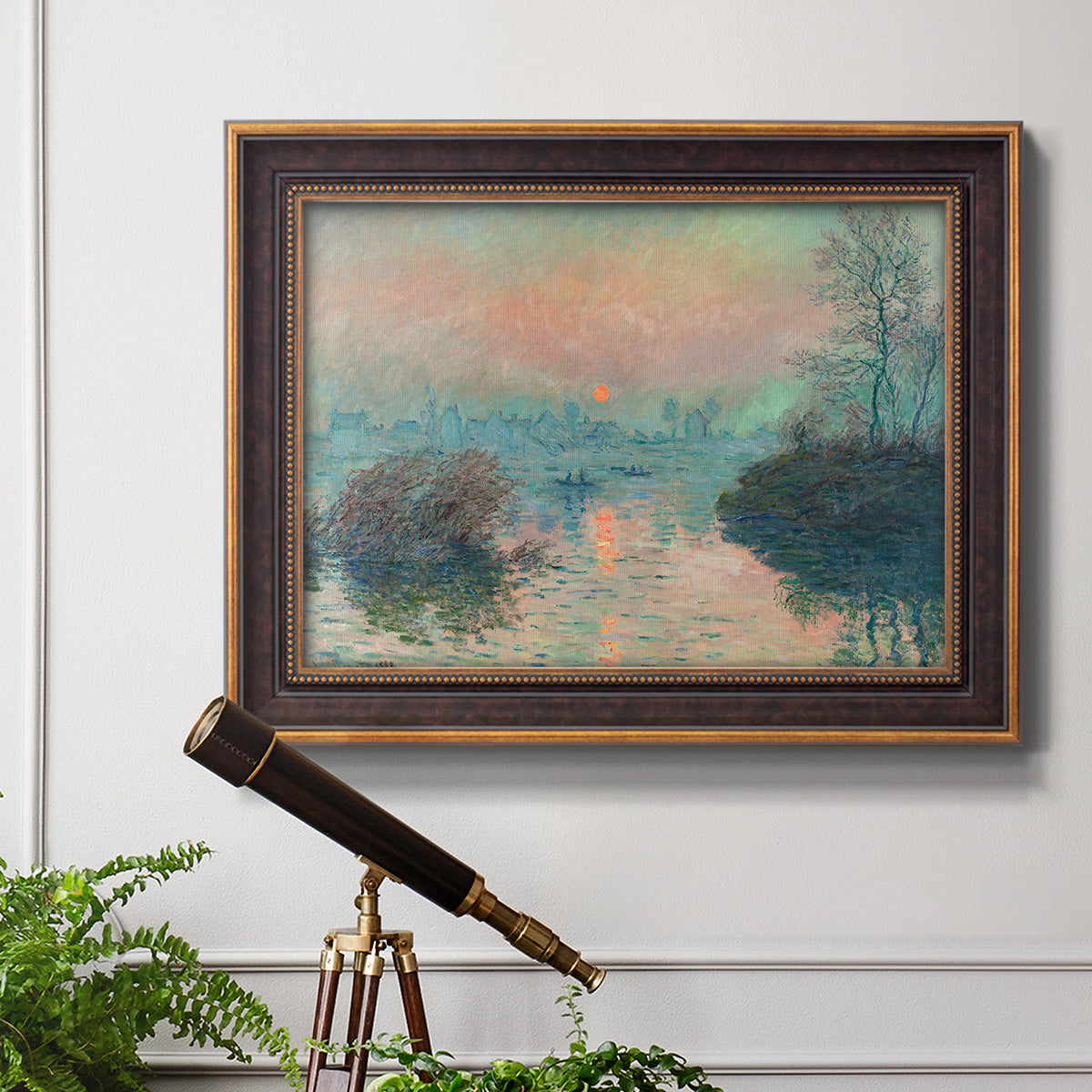 Impressionist winter river sunset scene by Claude Monet in an ornate bronzed mahogany wood frame displayed in a light-toned interior setting.