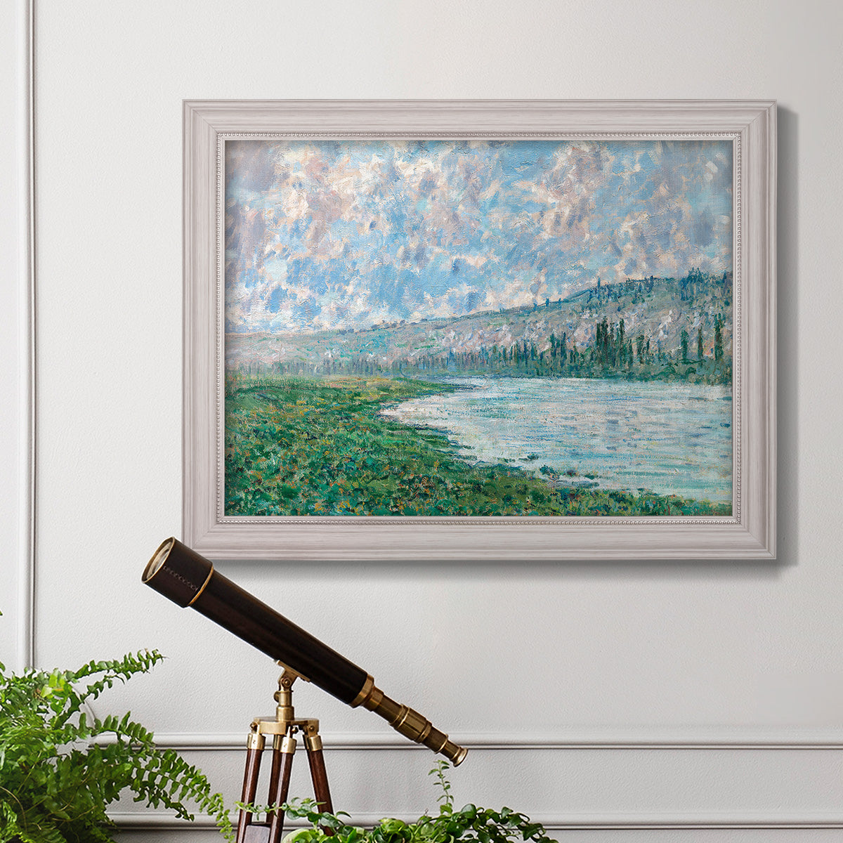 Impressionist river landscape at Vétheuil by Claude Monet in an ornate weathered white frame displayed in a light-toned interior setting.